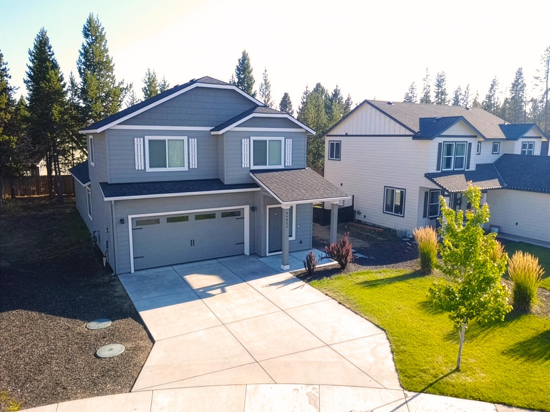Two-story blue home at 16625 Landing Court with a two-car garage, concrete driveway and landscaped front yard Two-story blue home at 16625 Landing Court with a two-car garage, concrete driveway and landscaped front yard