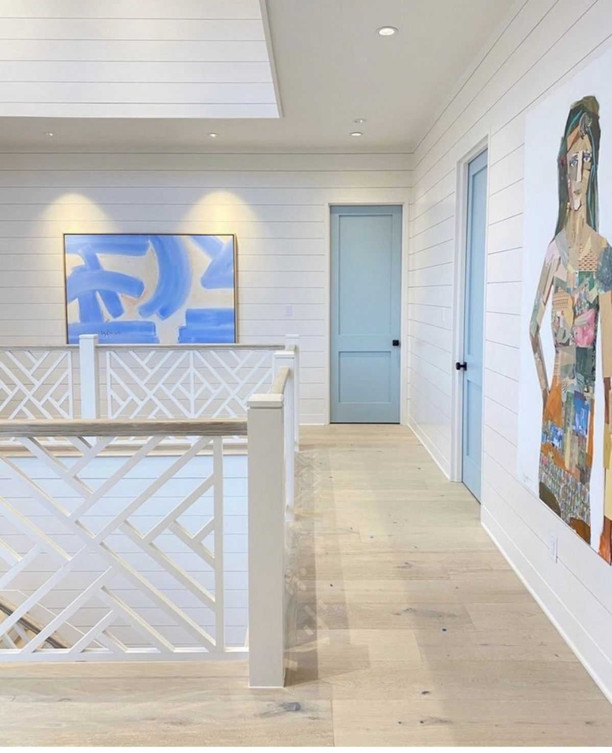 Bright coastal home interior with custom railing and original artwork