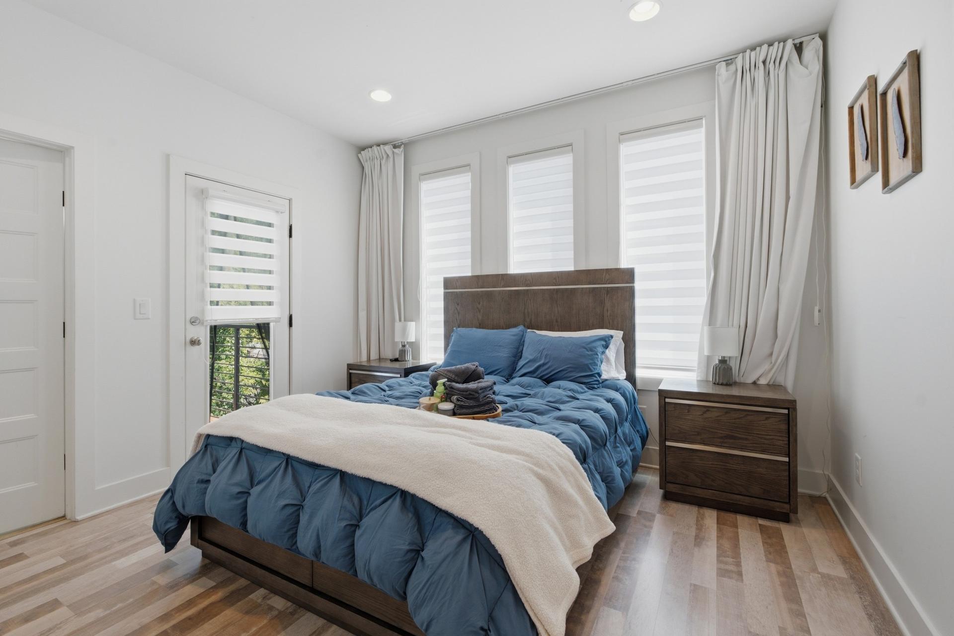 Primary bedroom with blue bedding and natural light
