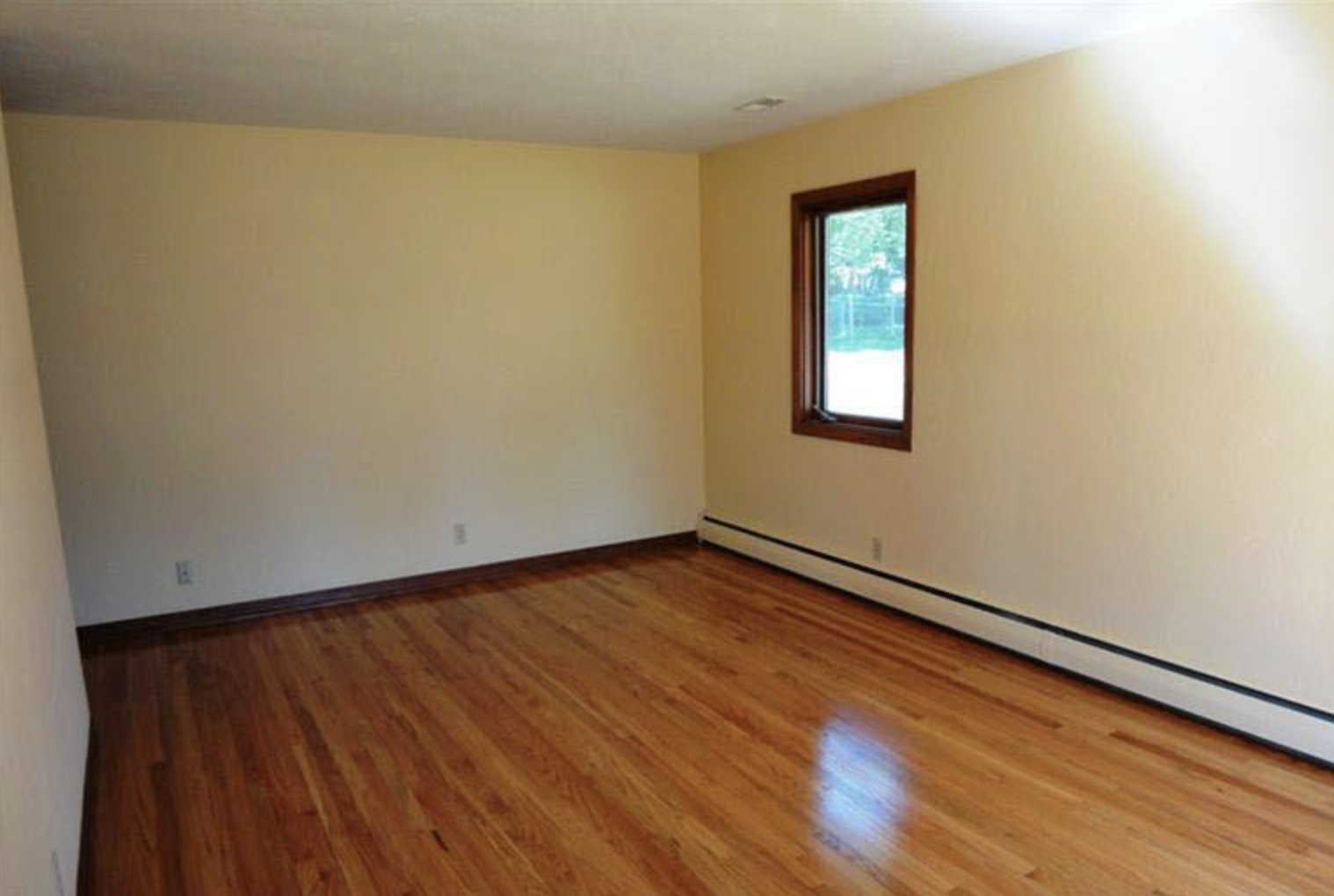 Empty hardwood-floor living room before staging